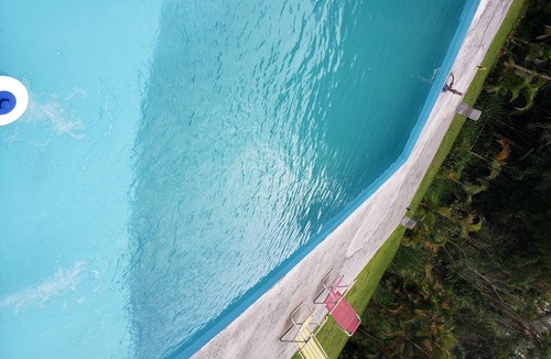 Suzano House | Country house with swimming pool, barbecue area and lots of greenery.